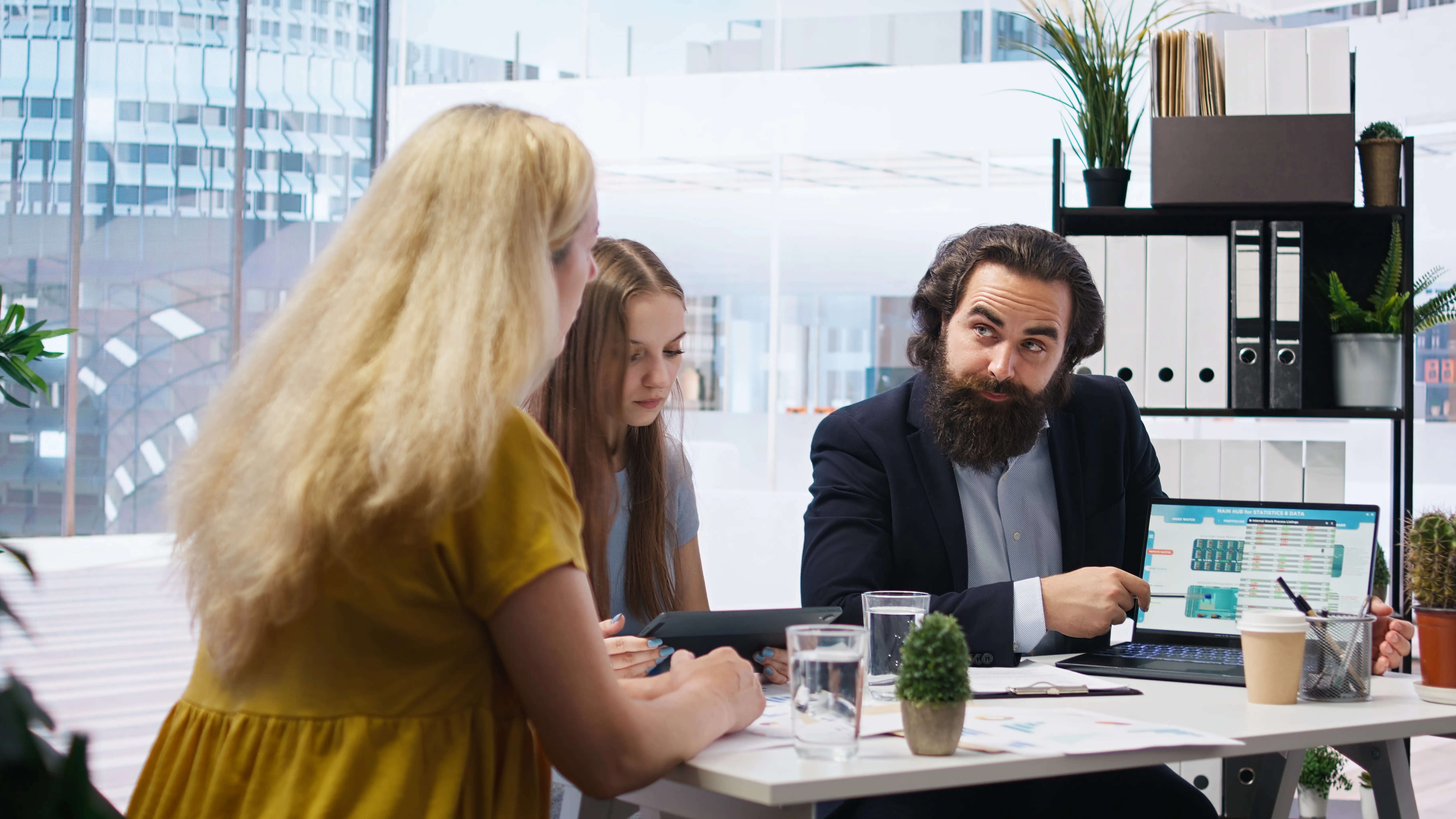 Ein Finanzberater betrachtet mit Kunden im Büro das Wachstum der Marktanteile.
